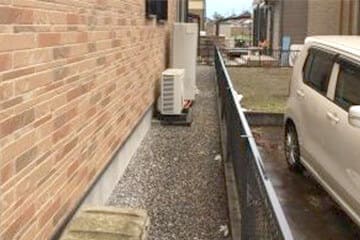 建物の外壁に設置されたエコキュートの貯湯タンクユニットの下部写真