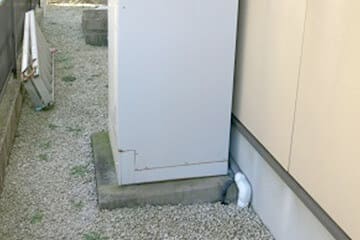 建物外壁に設置されたエコキュートの貯湯タンク下部の写真